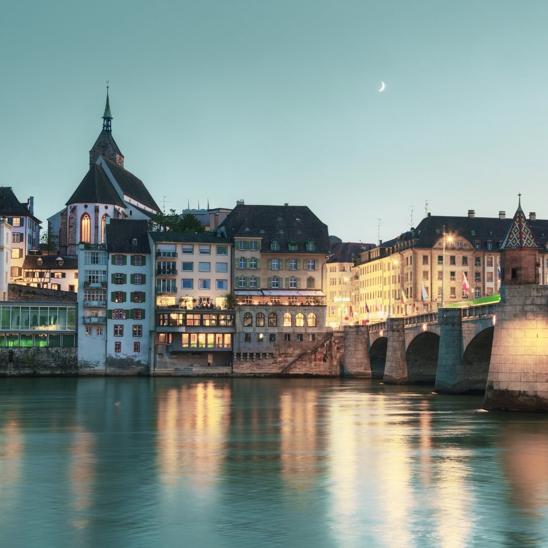 Historic Swiss old town by the lake at dusk, with warmly lit traditional buildings